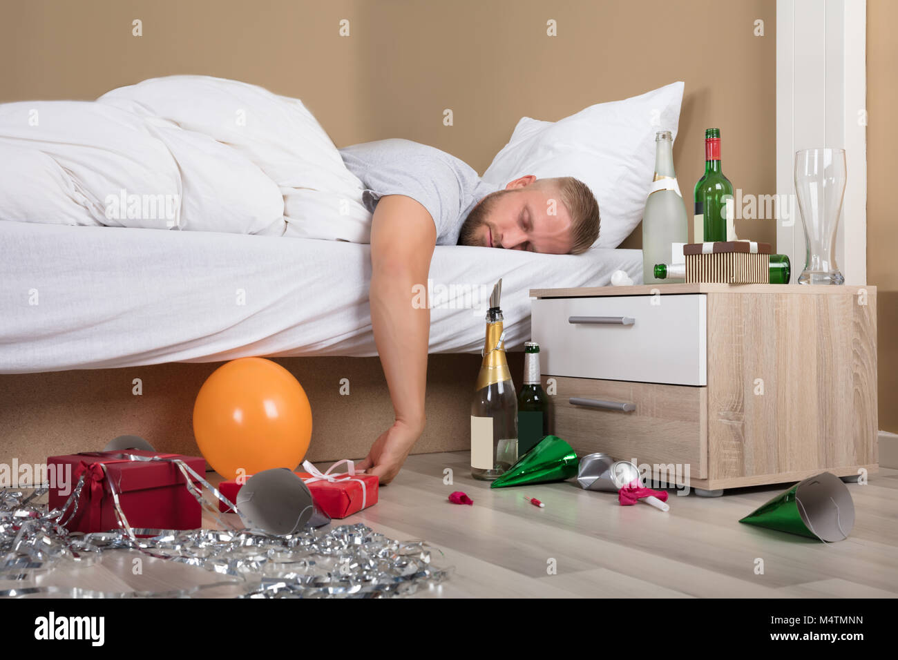 Junger Mann liegend auf Bett mit durcheinander gebracht, nach Partei Stockfoto