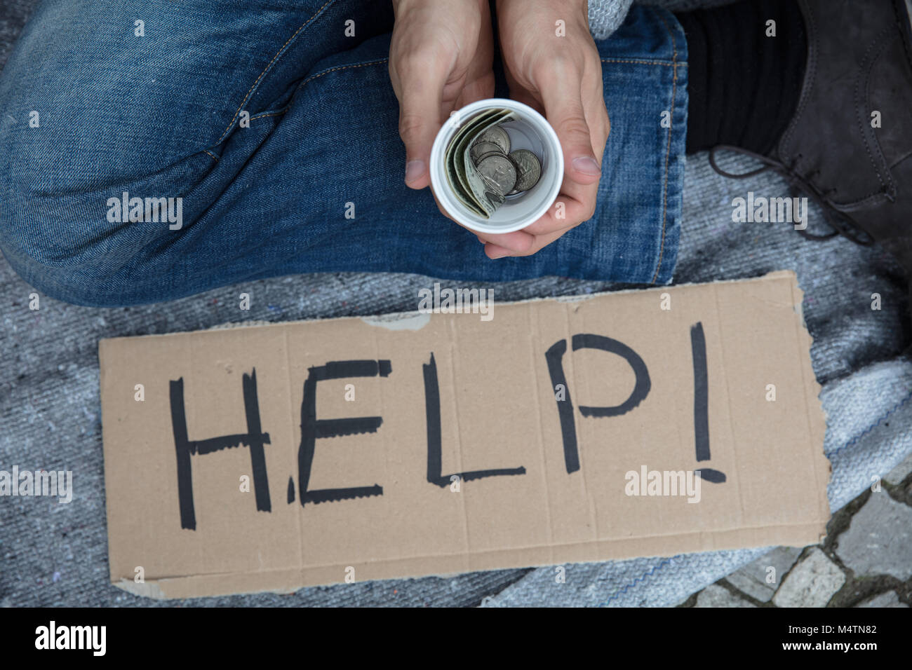Ansicht von Obdachlosen Mann mit Glas Geld um Hilfe zu bitten Stockfoto