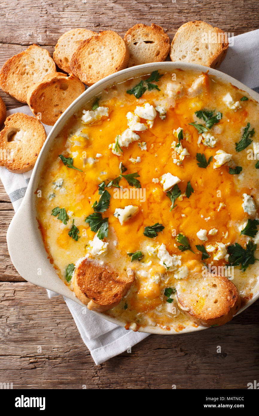 Huhn buffalo Dip mit Blauschimmelkäse und Grünen close-up in einer Auflaufform auf einem Tisch. Senkrechte Draufsicht von oben Stockfoto