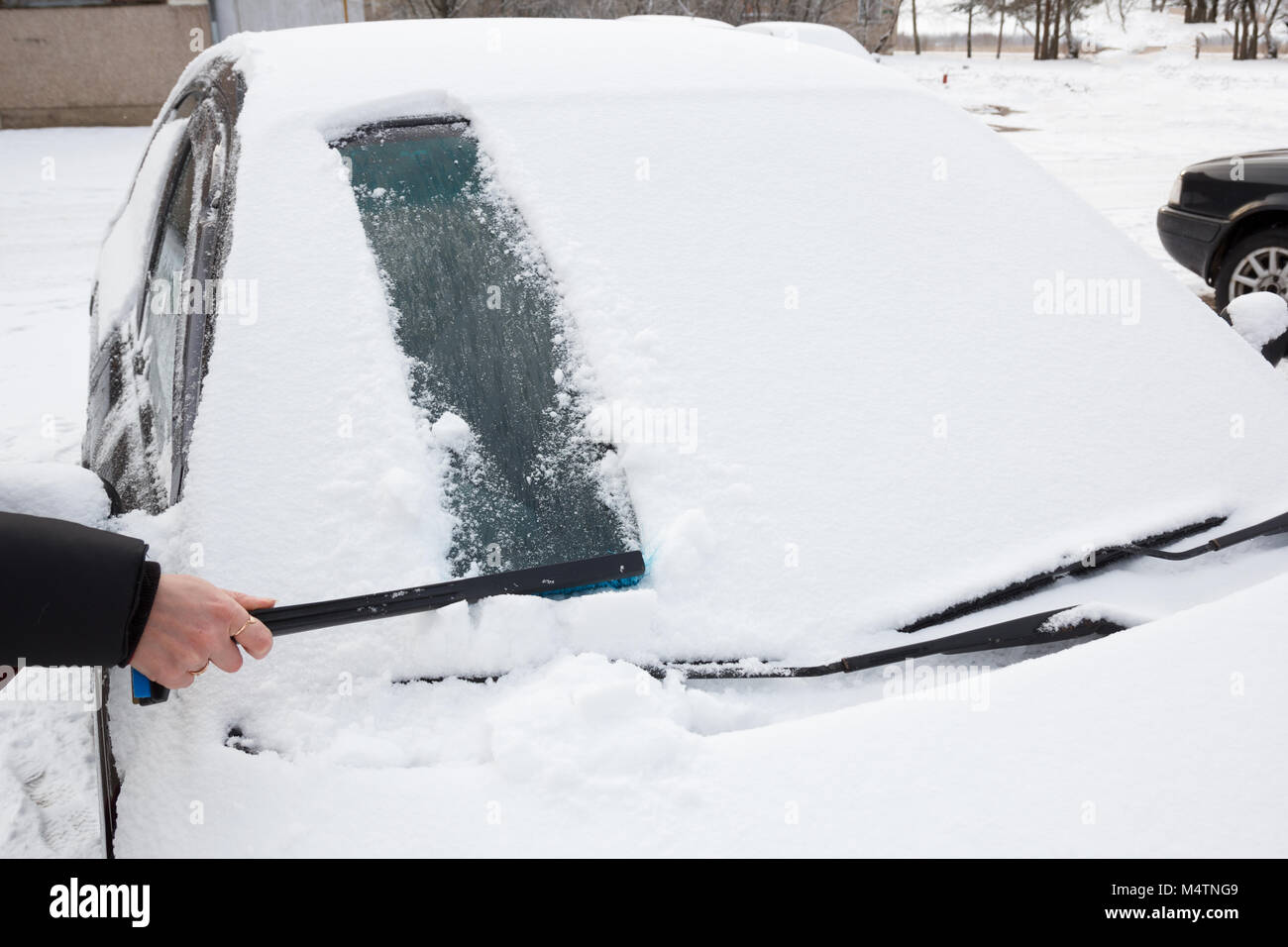 Reinigung des Autos aus Schnee mit Stockfoto 1875784192