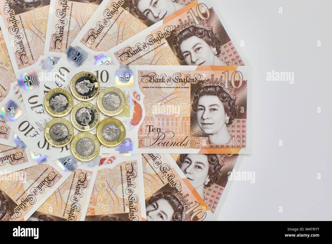 Das neue Polymer £ 10 Banknoten und die neue 12 seitige £ 1 Münzen auf weißem Hintergrund Stockfoto