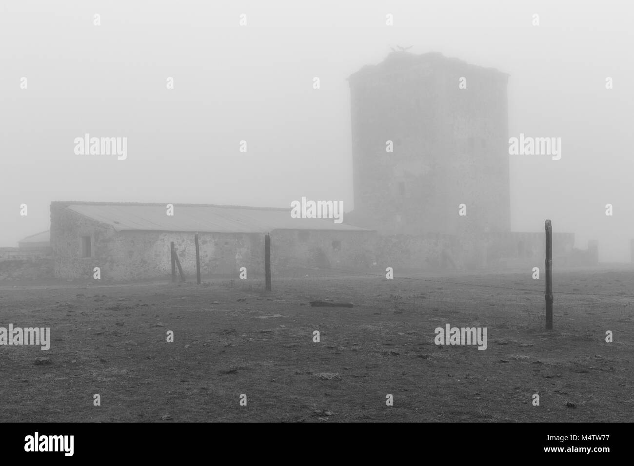 Turm der Mogollones. Landschaft mit einem mittelalterlichen Turm in Nebel gehüllt. Der Extremadura. Spanien. Stockfoto