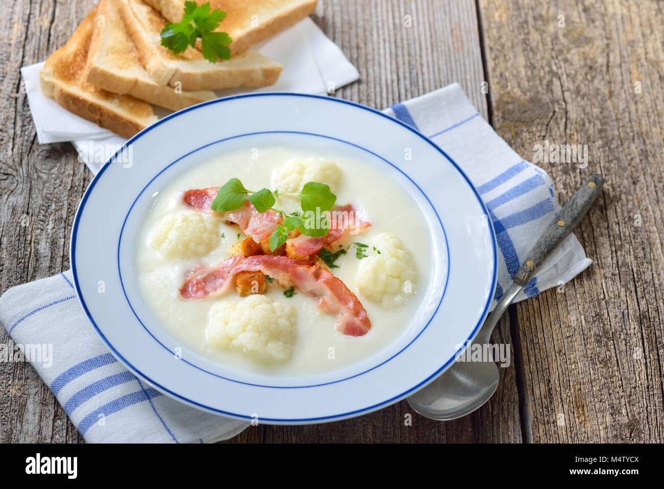 Lecker Blumenkohl Cremesuppe mit gebratenen Speck und frischen Croutons, serviert mit frischen Toast Stockfoto