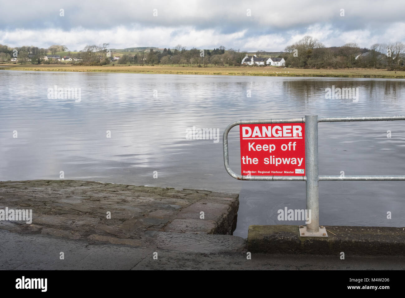 Blick über den Fluss Dee von der Hangbahn am Hafen von Kirkcudbright im Südwesten Schottlands, mit Gefahrenschild. Stockfoto