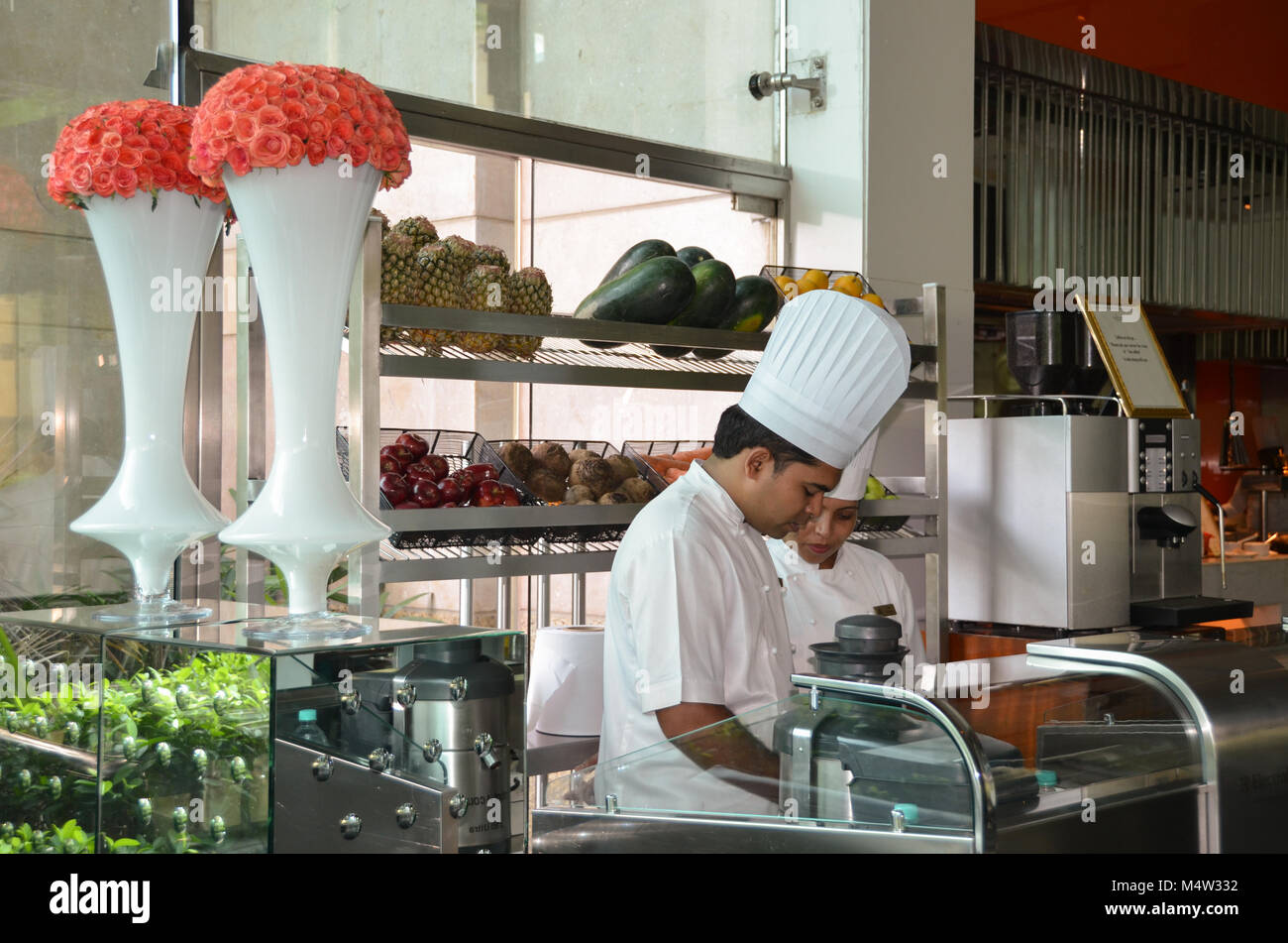 Köche, trug hohe weiße Hauben, Essen am Frühstücksbuffet im Leela Palace, a luxury hotel in Delhi, Indien vorzubereiten. Stockfoto