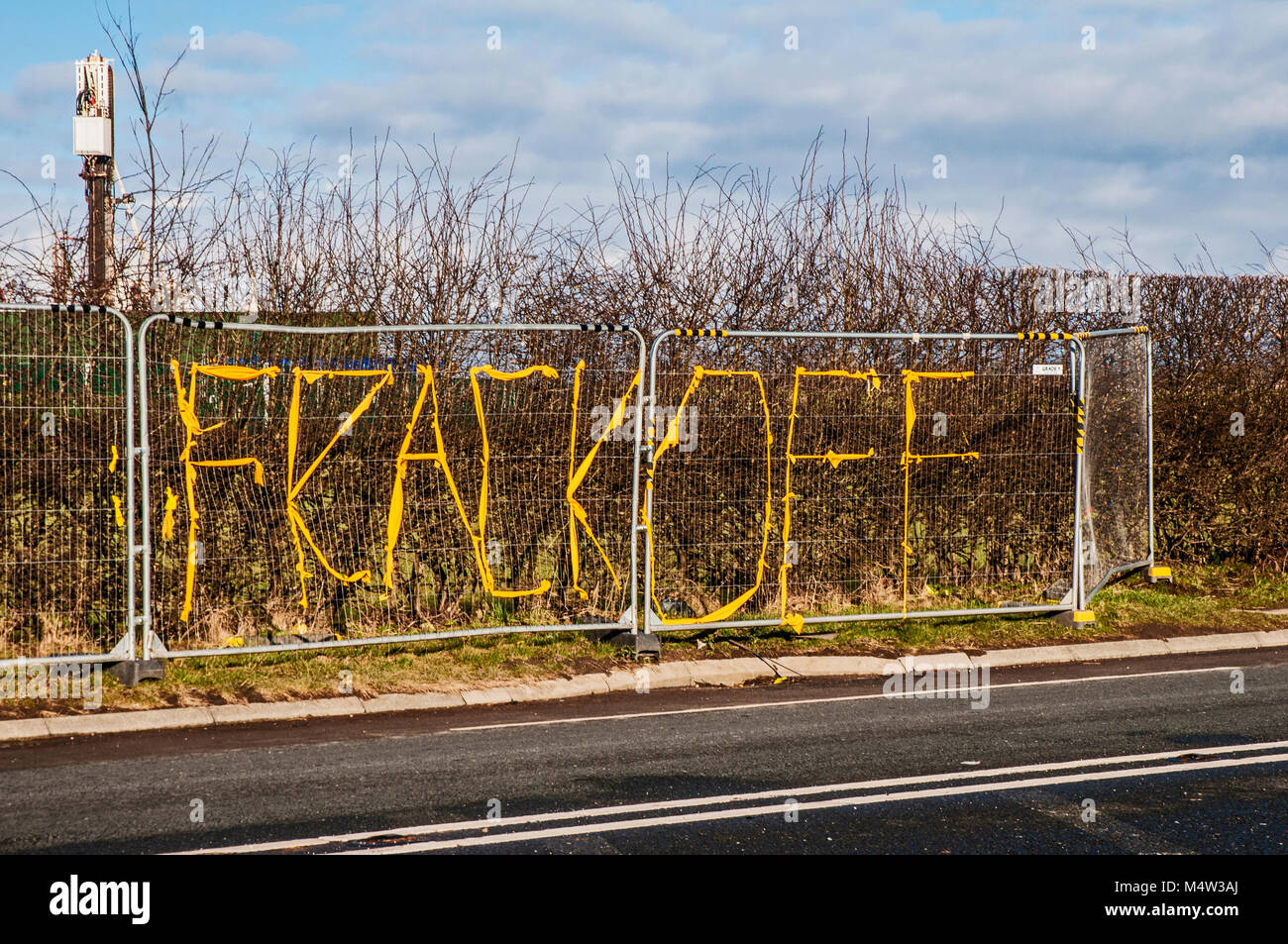 Banner gegen Schiefergas-Fracking, die an Hecken entlang der A583 Preston New Road bei Little Plumpton Lancashire UK angebracht sind, mit Bohrgerät vor Ort Stockfoto