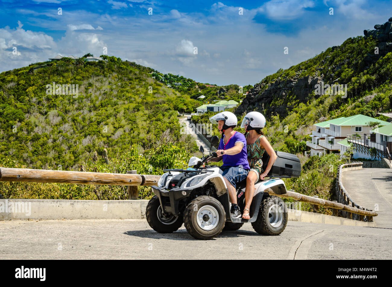 Abenteuerliche paar Fahrten ein ATV auf steilen Straße der Westindischen Insel St. Barth. Stockfoto