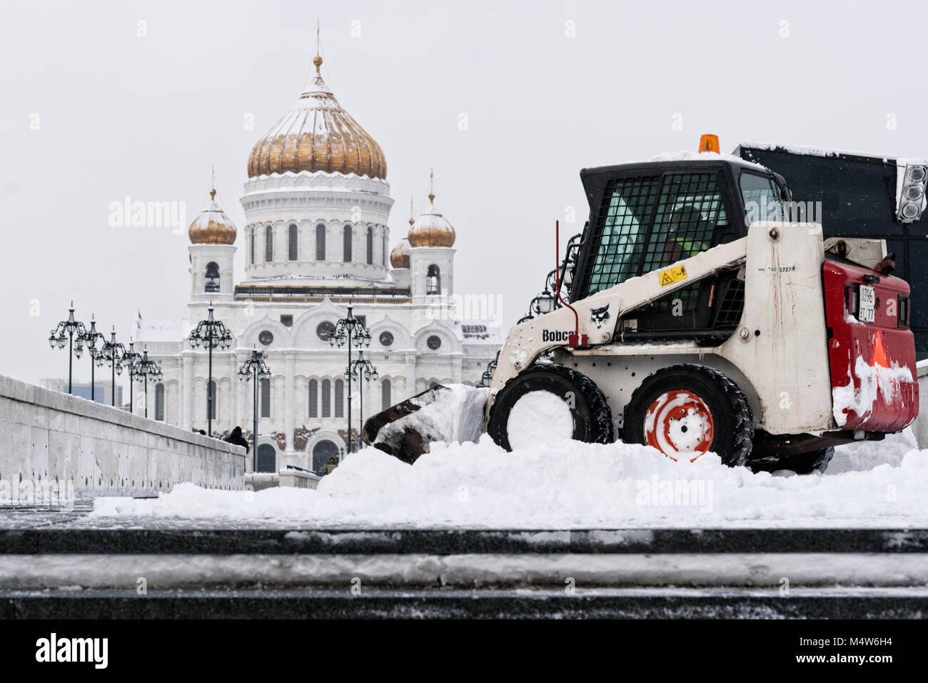 Moskau, 5. Februar 2018: Bobcat Kompaktlader Fahrzeug entfernt Schnee von Patriarch Brücke nach dem Schneesturm. Bobcat ist ein führender USA Firma. Stockfoto