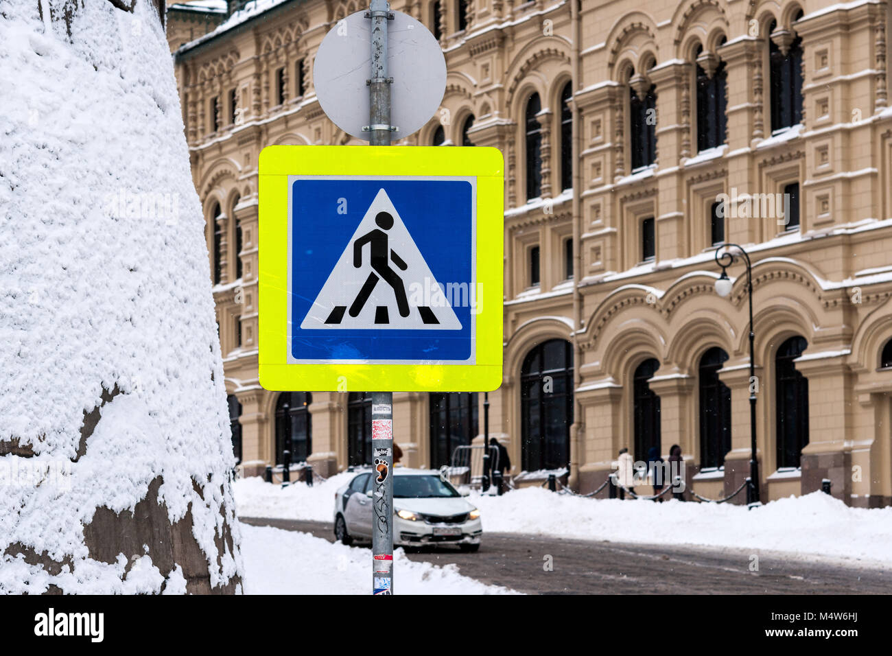 Moskau, 5. Februar 2018: Gelb und Blau lackiert Fußgängerüberweg Straße Warnschild auf einer verschneiten Straße in der Nähe vom Roten Platz entfernt. Stockfoto