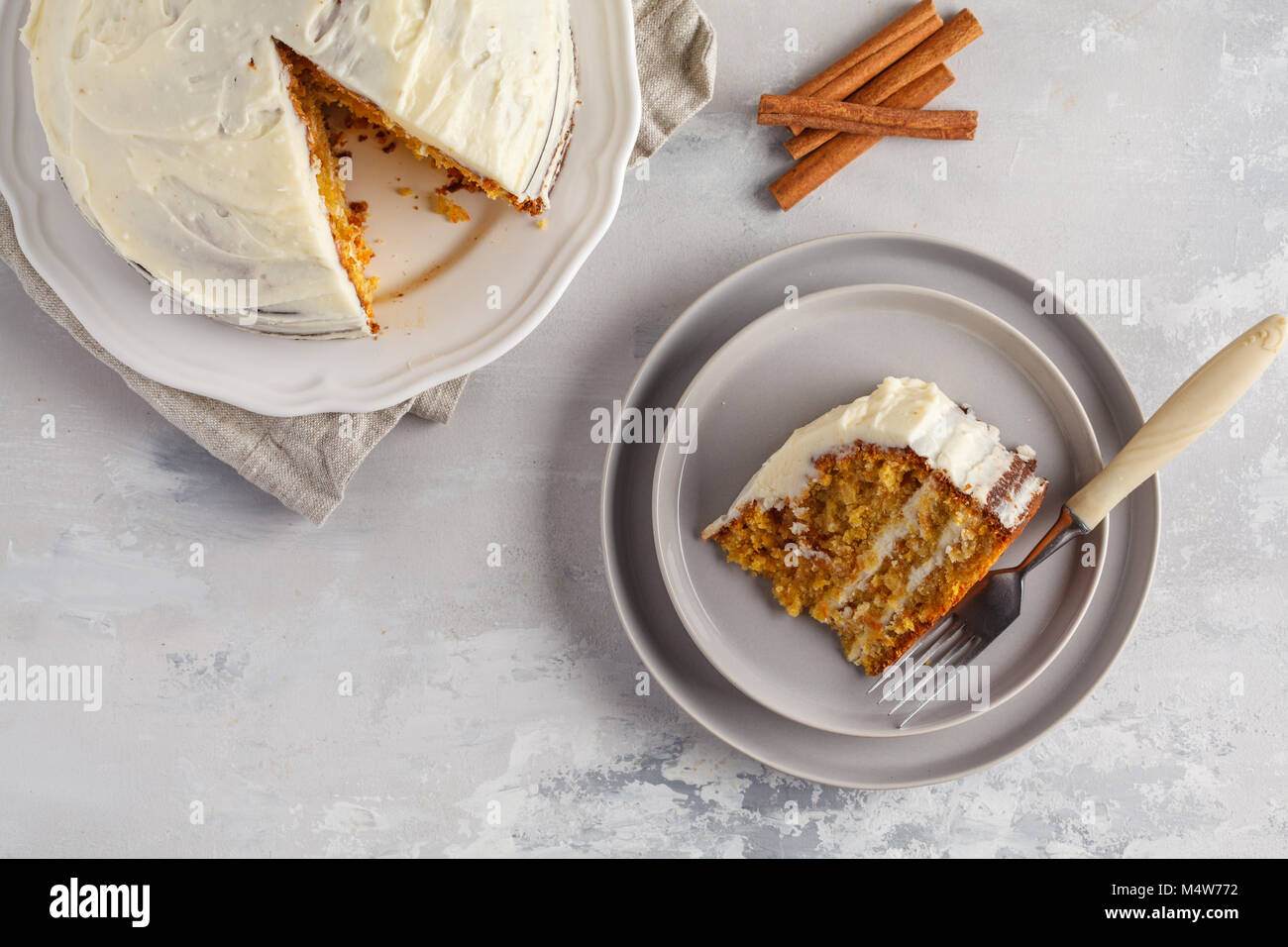 Stück Karotte hausgemachte Kuchen mit Weiß Creme auf grauem Hintergrund. Festliches dessert Konzept. Stockfoto