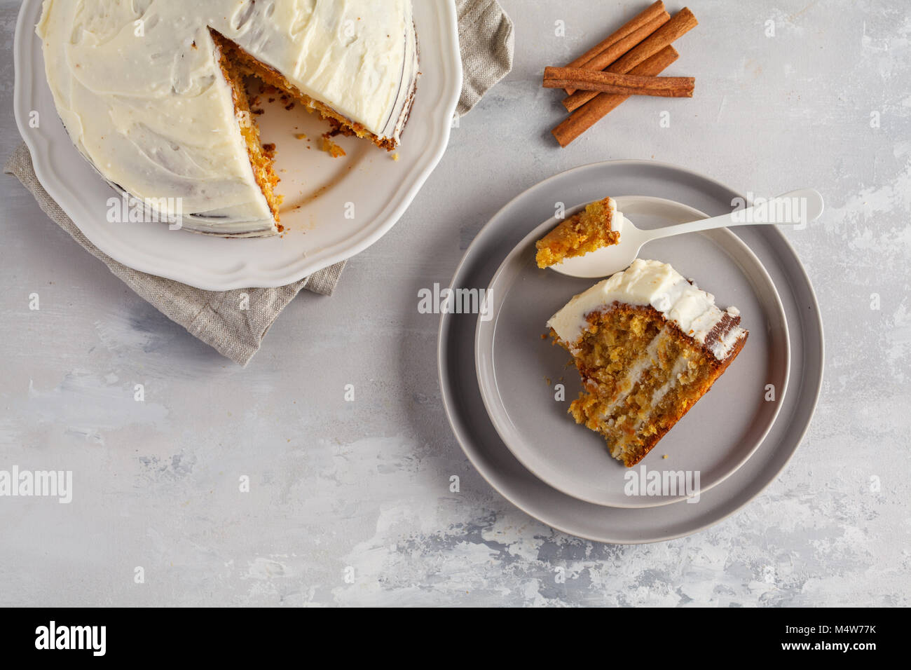 Stück Karotte hausgemachte Kuchen mit Weiß Creme auf grauem Hintergrund. Festliches dessert Konzept. Stockfoto