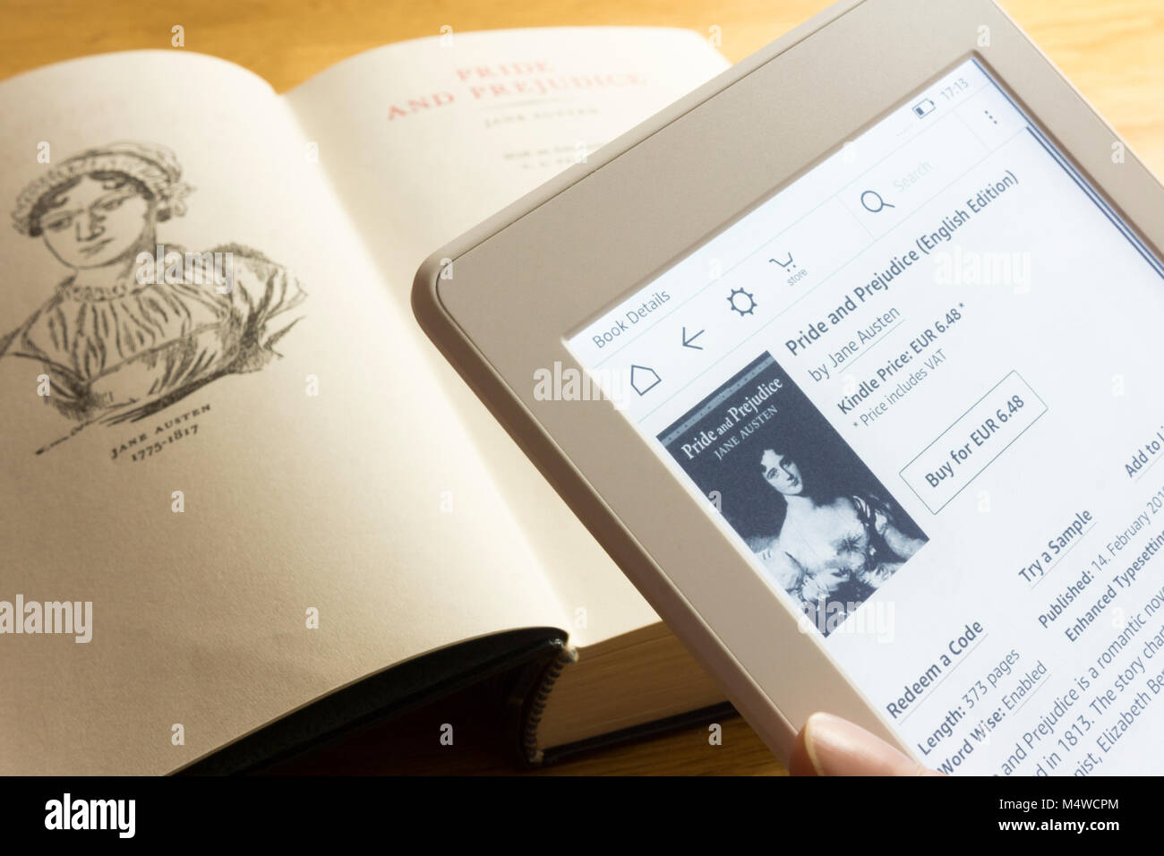 Ein Kindle Paperwhite mit einem Ebook Version von Stolz und Vorurteil und ein Hardcover Buch kopieren Stockfoto