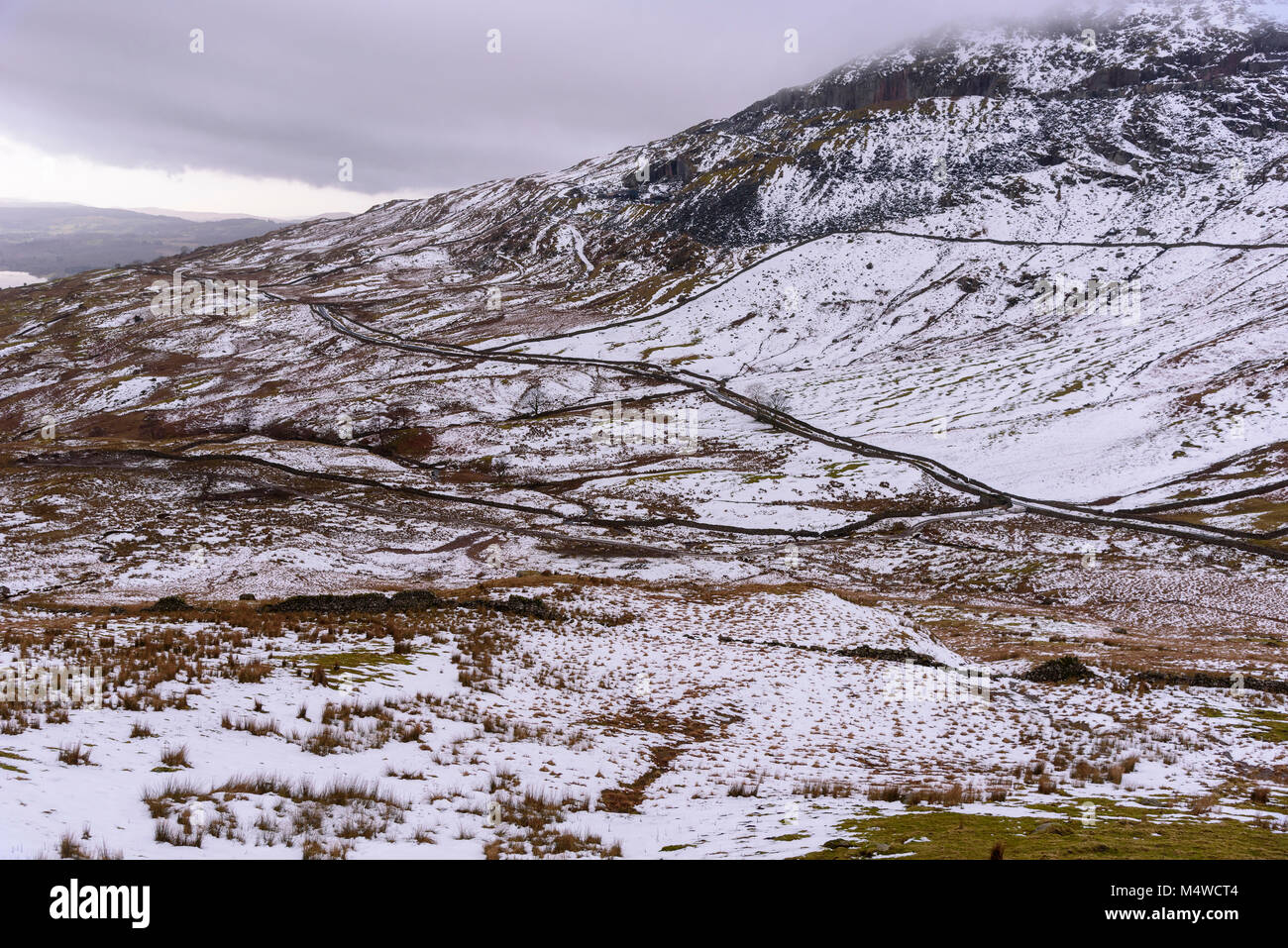 Die Straße btween Ambleside und Patterdale als Kampf bekannt schlängelt sich der Schnee in Richtung der Kirkstone pass fiel. Stockfoto