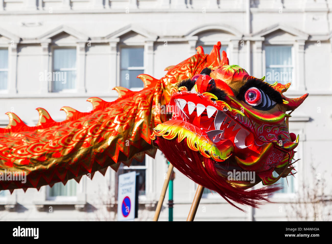 Nahaufnahme mit dem leuchtenden orange farbigen Drachen als es tanzt durch die Straßen von Liverpool Chinatown in das neue Jahr feiern. Stockfoto