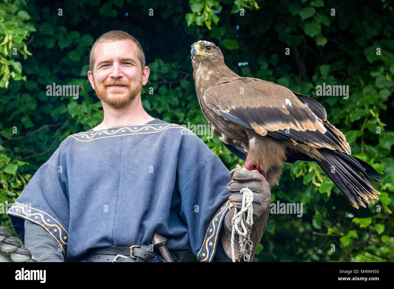 Ein Mann in mittelalterlichen Kleidern mit einem Falken, Esrum gekleidet, Dänemark Stockfoto