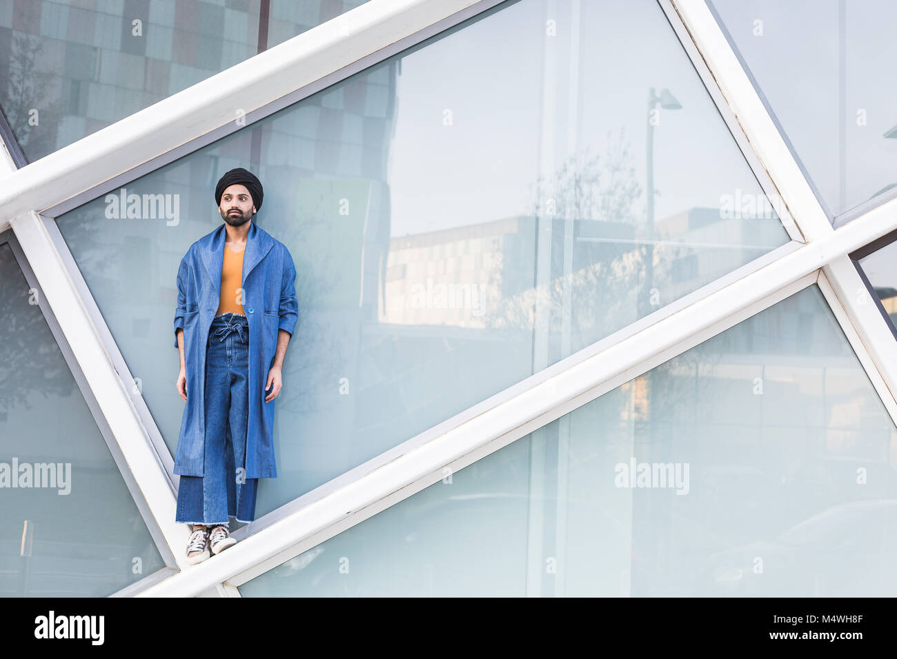 Schöner indischer Mann posiert im urbanen Kontext. Street-Fashion und Style. Stockfoto