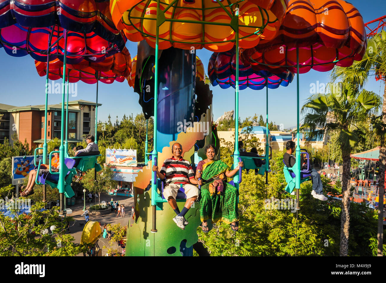 Indische Paare, die Frau, gekleidet in einem grünen Sari, reiten Sie die Jumpin' Quallen paratower Fallschirm Fahrt im Disneyland in Kalifornien. Stockfoto