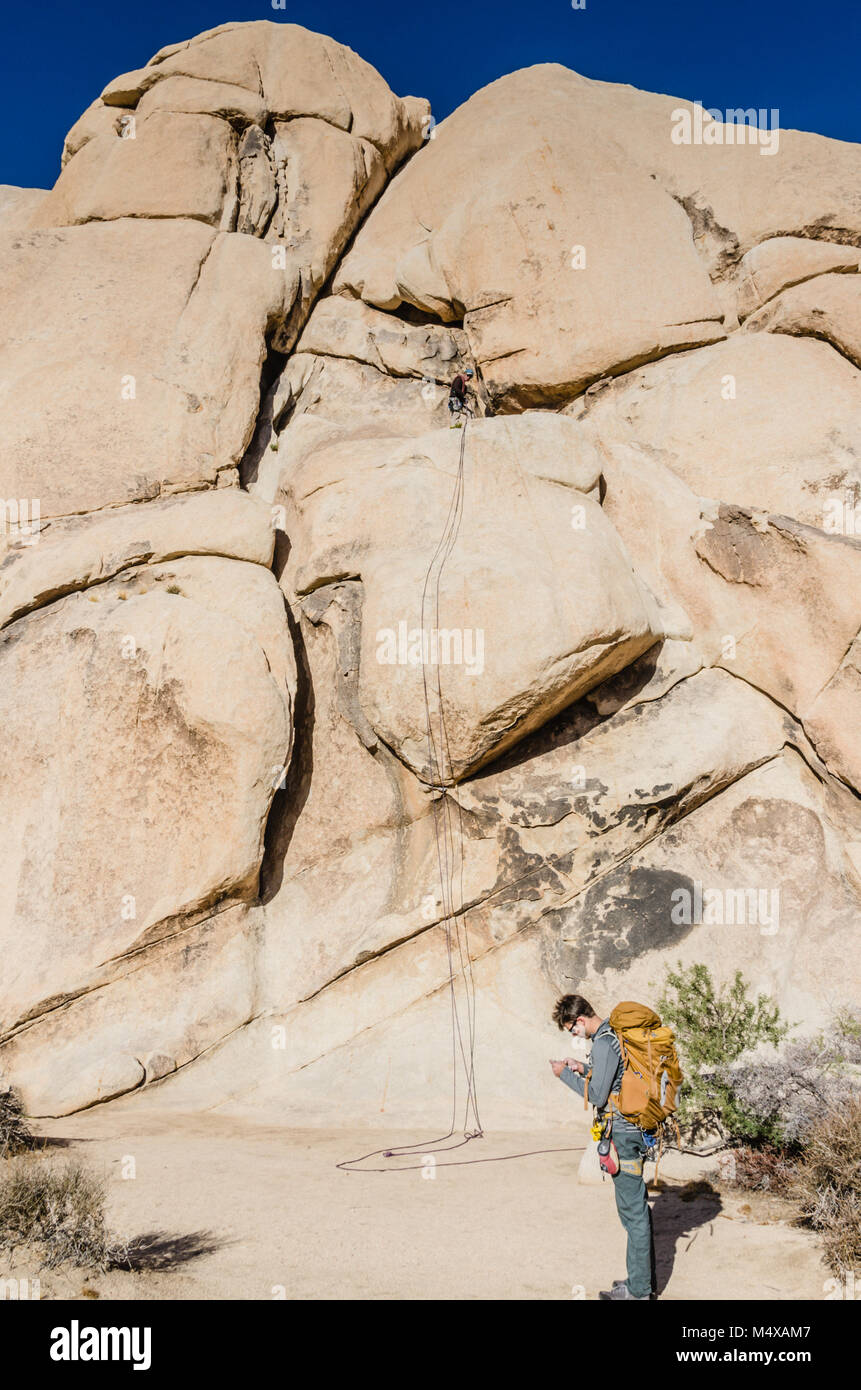 Junger Mann Lager full Pack plant seine Route vor Anker Seil auf der Kreuzung Rock, der Prominente 150 Fuß hohe Monzonite Monolith. Stockfoto