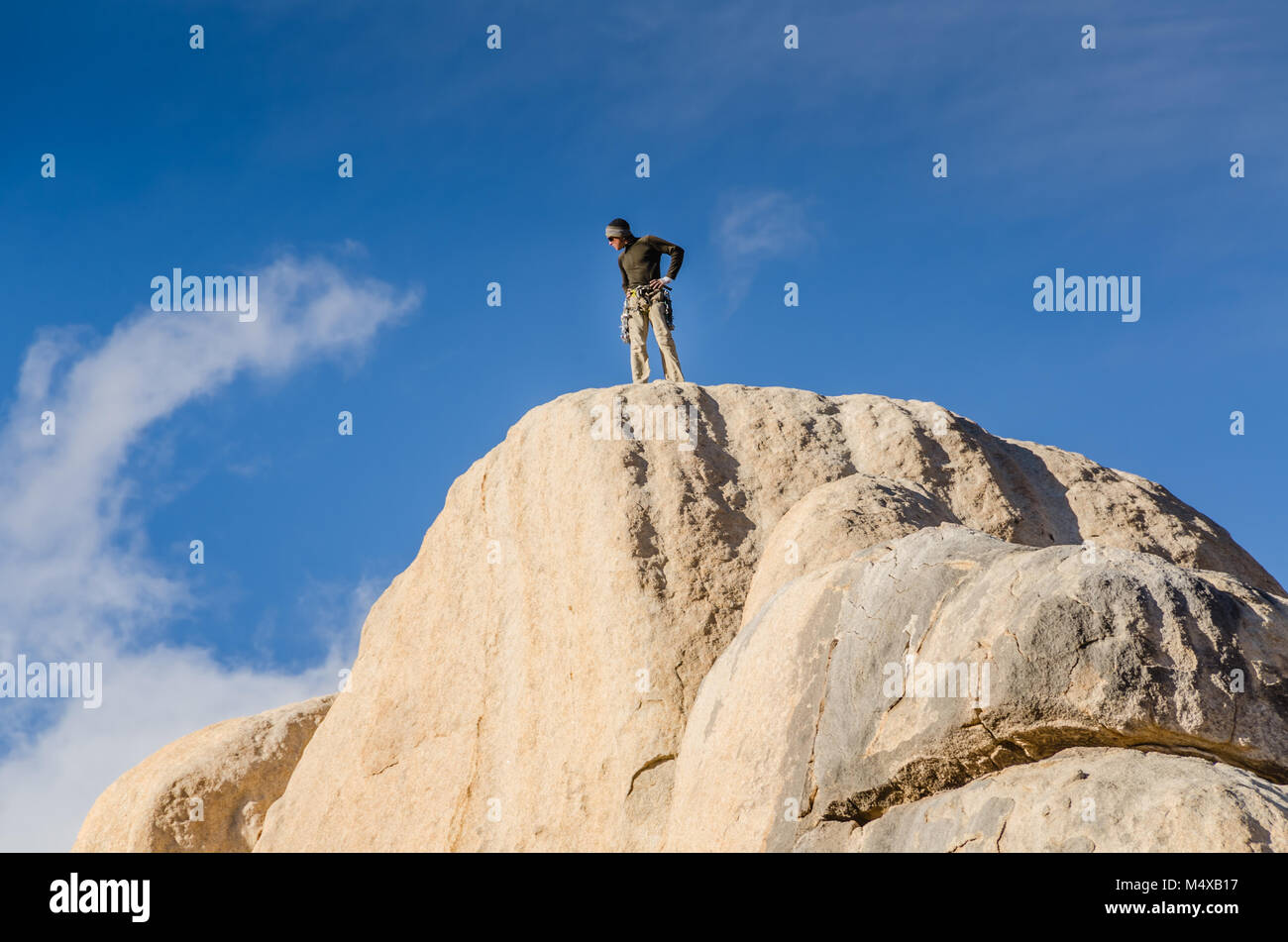 Ein männlicher Kletterer auf dem Gipfel der Kreuzung Felsen steht, der bekannte 150 Meter hohe Monzonite monolith anerkannt als der Geburtsort von climbi Stockfoto