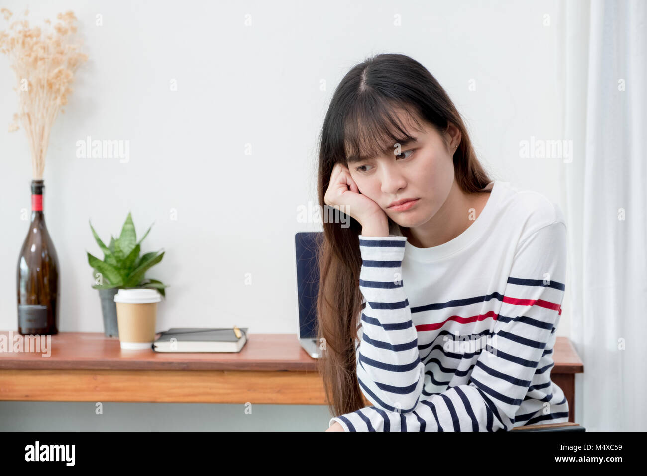 Asien Frau über das Arbeiten bei Cafe Restaurant gelangweilt, Weiblich rest Kinn auf der Hand mit Stress Gefühl mit Laptop und Kaffee Tasse auf dem Tisch im Coffee Shop, Bori Stockfoto
