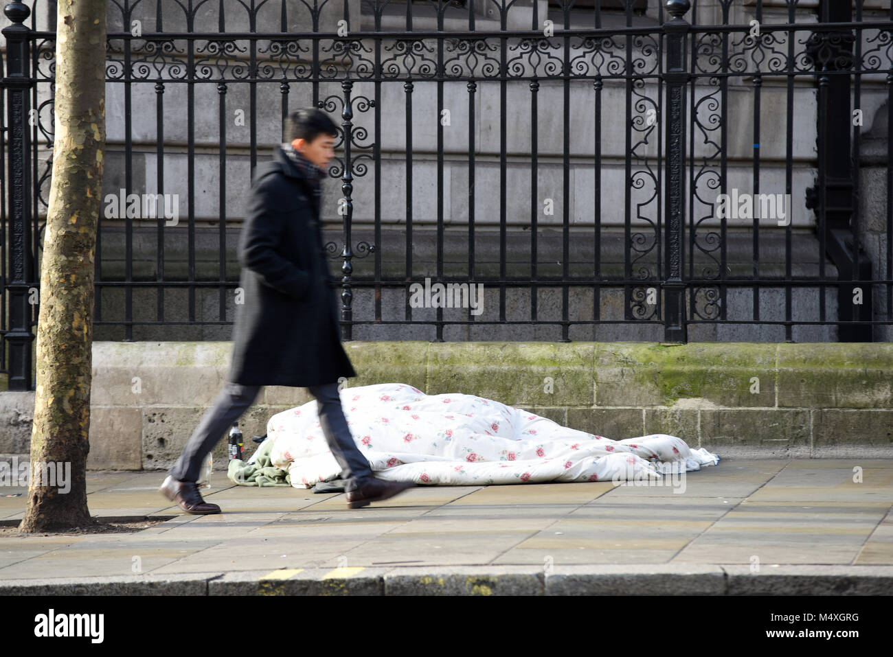 Zu Fuß durch obdachlose Person schlafen auf der Straße in London. Obdachlosigkeit. Passanten ignorieren rough Sleeper auf kalten Wintertag Stockfoto