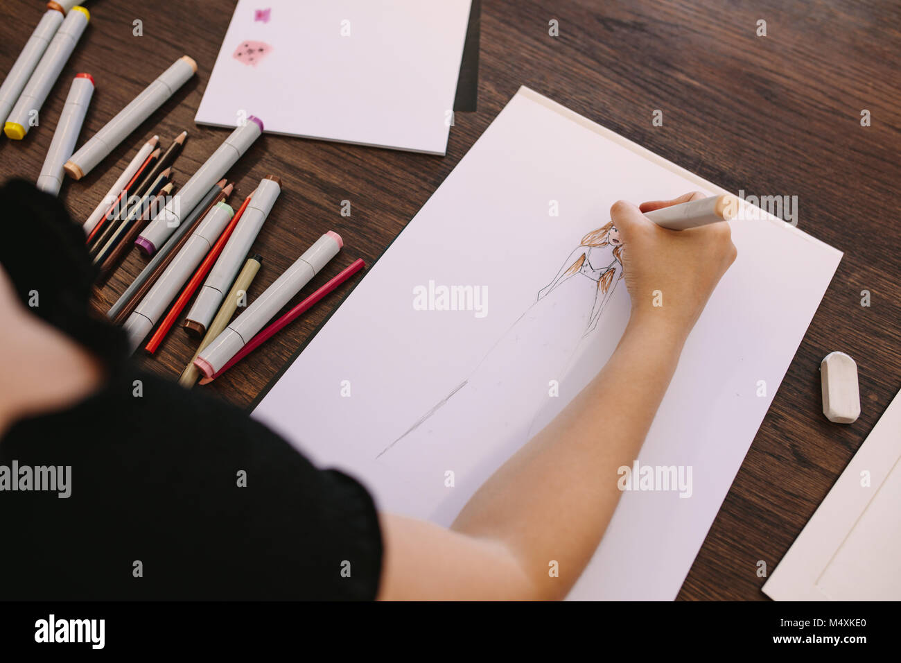 Weibliche Unternehmer Skizzieren eines Design auf Ihrem Tisch. 7/8 Schuß von Fashion Designer, eine Zeichnung an ihrem Schreibtisch. Stockfoto