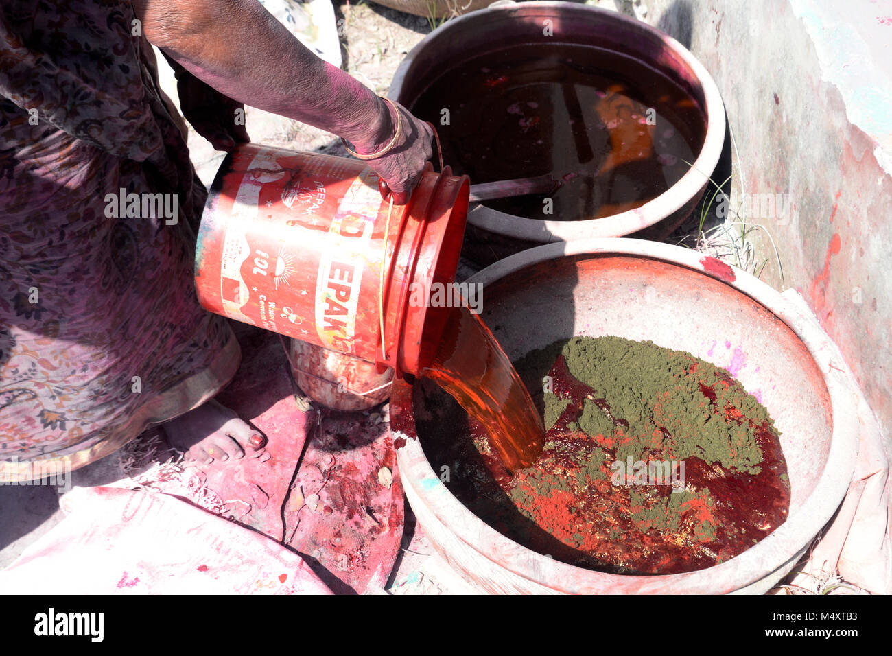 Kolkata, Indien. 18 Feb, 2018. Eine indische Frau gemischte Farbe mit Wasser während Abir oder Gulal oder Holi Farbe. Holi Farbe Entscheidungsträger beschäftigt zu machen Abir auch als Gulal bekannt oder Farbe vor bunten Festival von Holi und in diesem Jahr wird am 02. März gefeiert werden. Credit: Saikat Paul/Pacific Press/Alamy leben Nachrichten Stockfoto