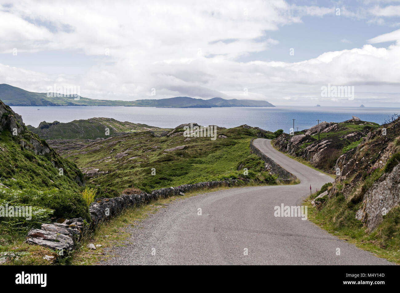 Eine schmale Küstenstraße, Teil des Ring of Beara in Südirland, gegenüber der Kenmore Bay zwischen Allihies und Eyeries auf der Beara-Halbinsel. Stockfoto