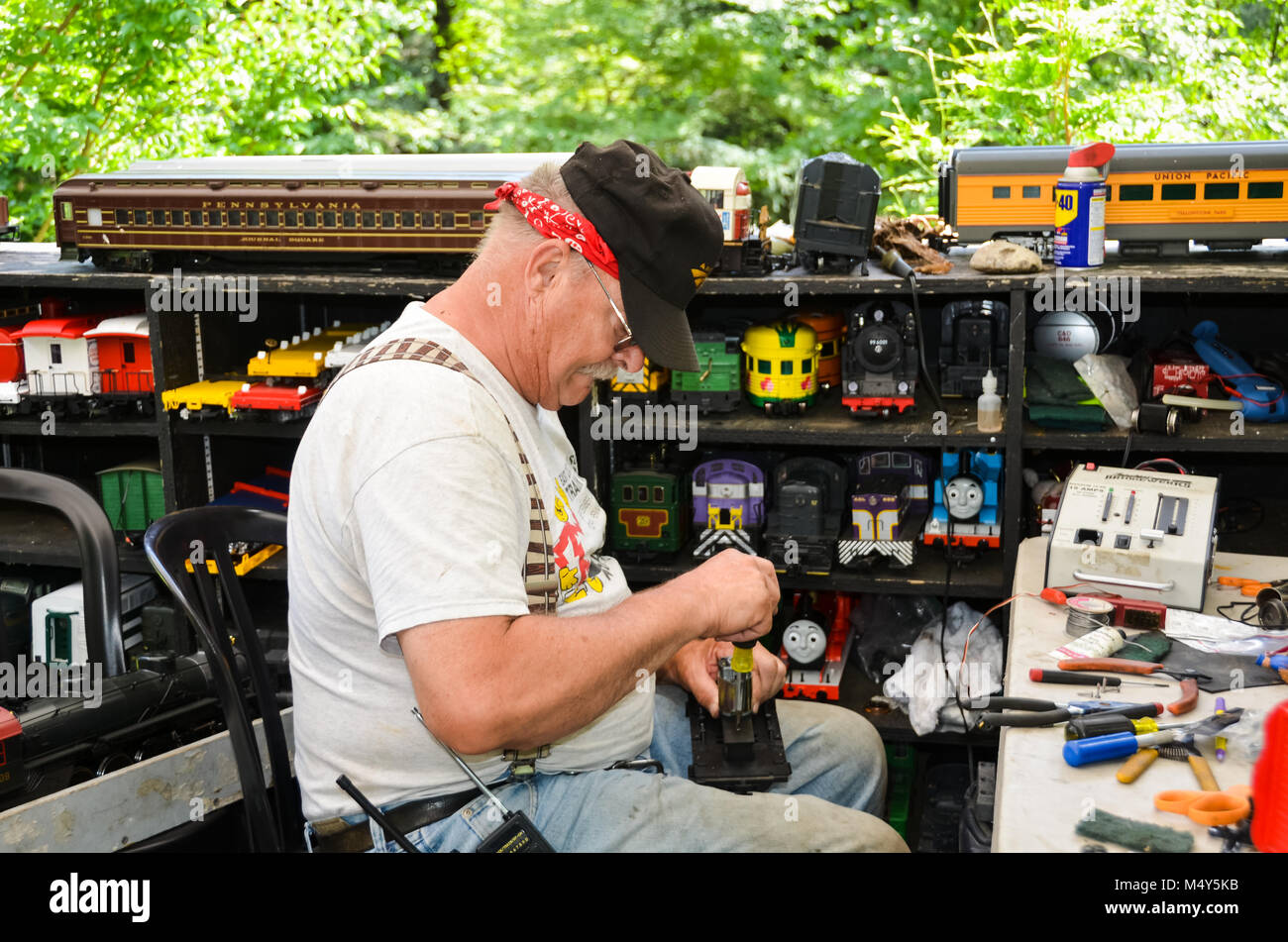 Modellbahn Techniker repariert Triebwagen im Garden Railway in Morris Arboretum der Universität von Pennsylvania, Philadelphia, PA, USA. Stockfoto