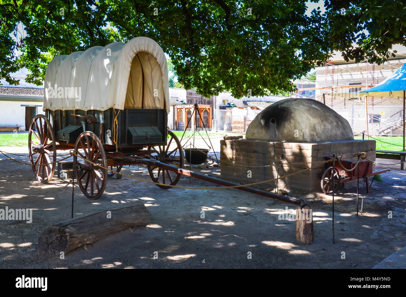 Planwagen und den Bienenstock Backofen im Freien Ausstellung bei Sutter's Fort historischer Ort in der Nähe von Sacramento, CA. Stockfoto