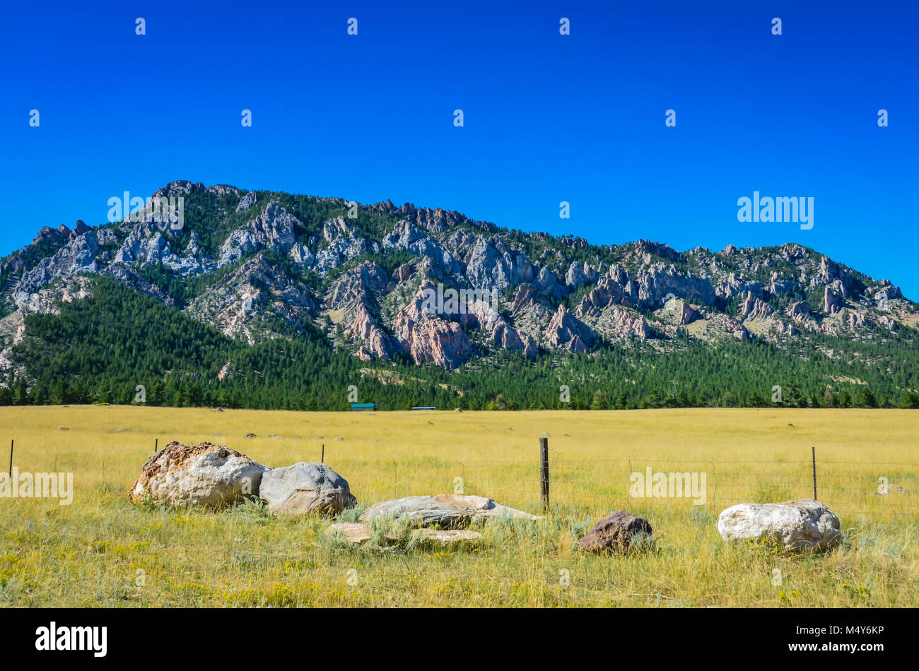 Felsbrocken, Stacheldraht, und einen Blick auf den Big Horn Ausläufern auf verrückte Frau Straße. Stockfoto