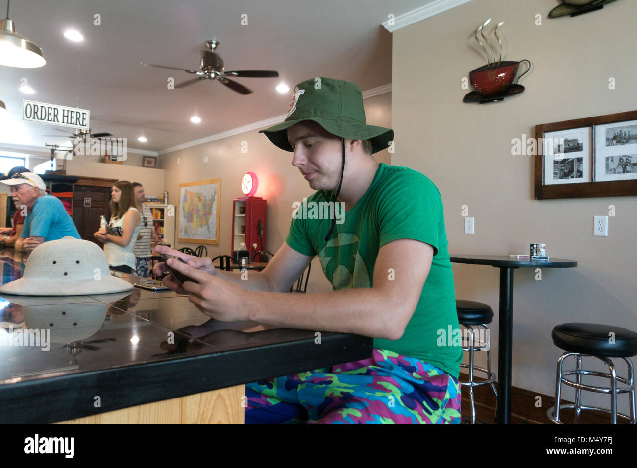 Teenager im Sommer gang Reaktion auf seinem Handy an Gerechtigkeit zwei Café & Restaurant. Clitherall Minnesota MN USA Stockfoto