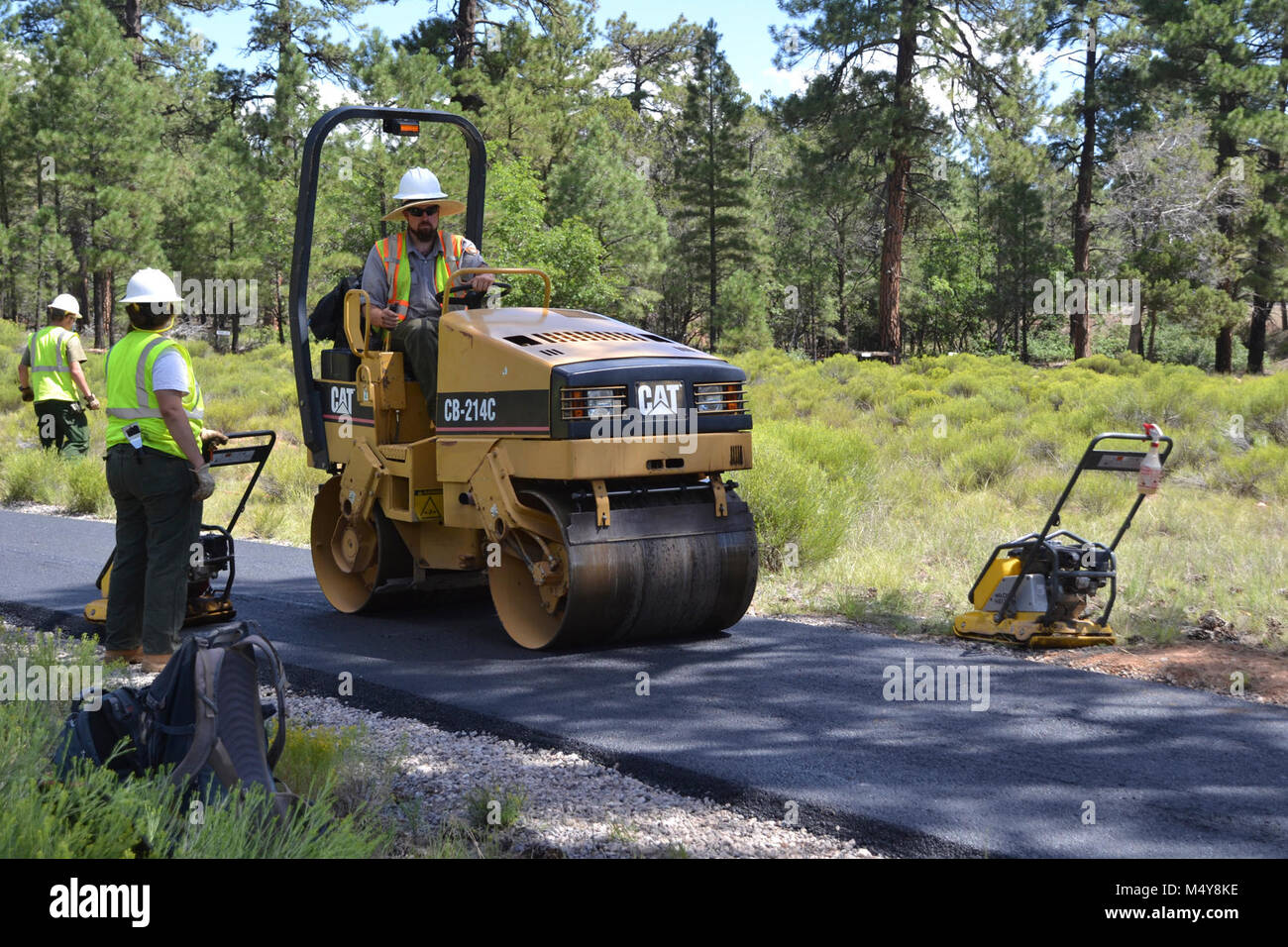 Ein Arbeiter glättet über den Asphalt auf einem Straßenfertiger. Zwischen 10. August bis 10. September 2016 die Greenway Trail zwischen dem IMAX Theater Parkplatz in Tusayan und Centre Road im Grand Canyon National Park wird geschlossen werden, während der Grand Canyon Trail crew installiert Asphalt. Der Teil der Trail im Norden von der Mitte der Straße nicht beeinträchtigt werden. Während die trail Schließung in Kraft ist, Radfahrer und Wanderer können die Tusayan Shuttle (lila Route), die mit Fahrradträger Racks ausgestattet ist. Der Shuttle verbindet Tusayan mit den South Rim Visitor Zentrums, jeweils eine 20-minütige Fahrt. Die Absicht dieser Proje Stockfoto