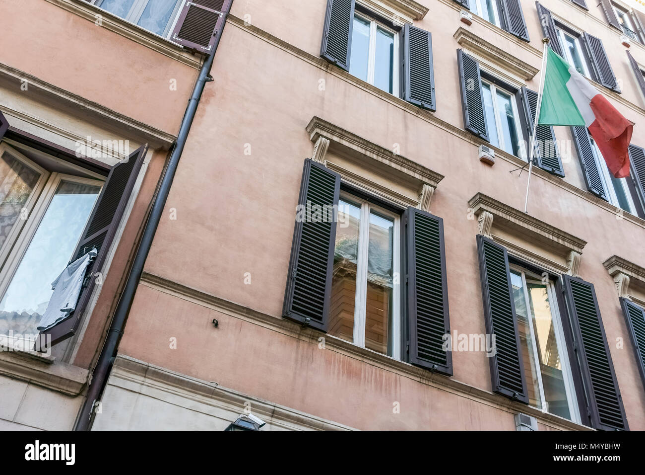 Flagge mit italienischer Flagge. Kleidung, die an einem Fensterladen eines Wohnhauses im Stadtzentrum von Rom, Italien, Europa, der Europäischen Union, der EU hängt. Stockfoto
