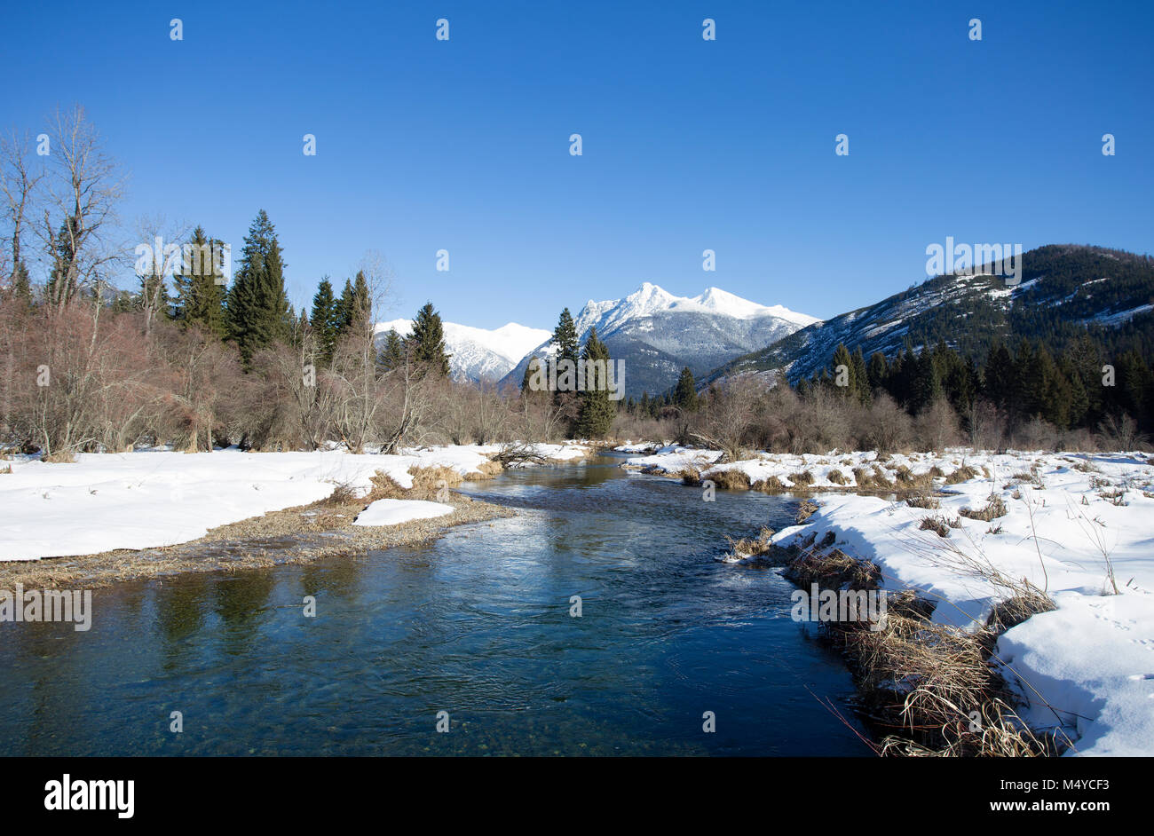 Bull River, North, mit Ibex Peak und Schneeschuh Gipfel im Kabinett Berge in der Ferne, an einem kalten, klaren Tag. Stockfoto