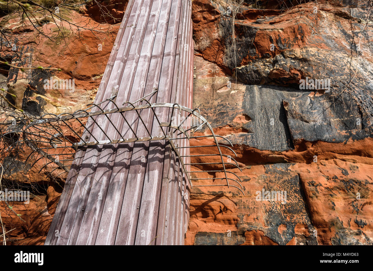 Ein Metall rutsche Struktur mit einem Security Barrier in Sandsteinfelsen. Stockfoto