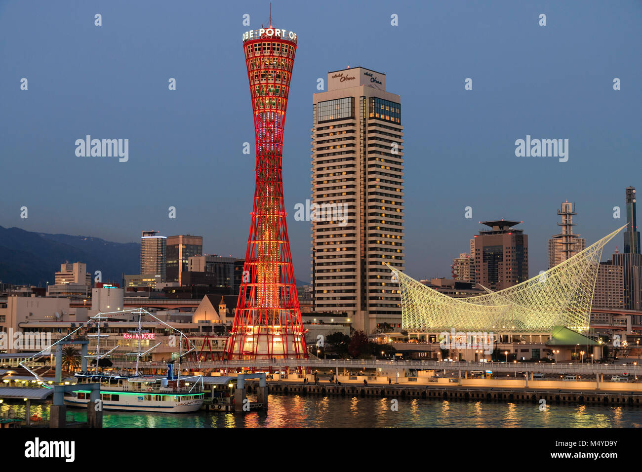 Japan, Kobe. Red Kobe-hafen, mit Okura Hotel hinter, und das Maritime Museum. Nacht, Dämmerung. Stockfoto