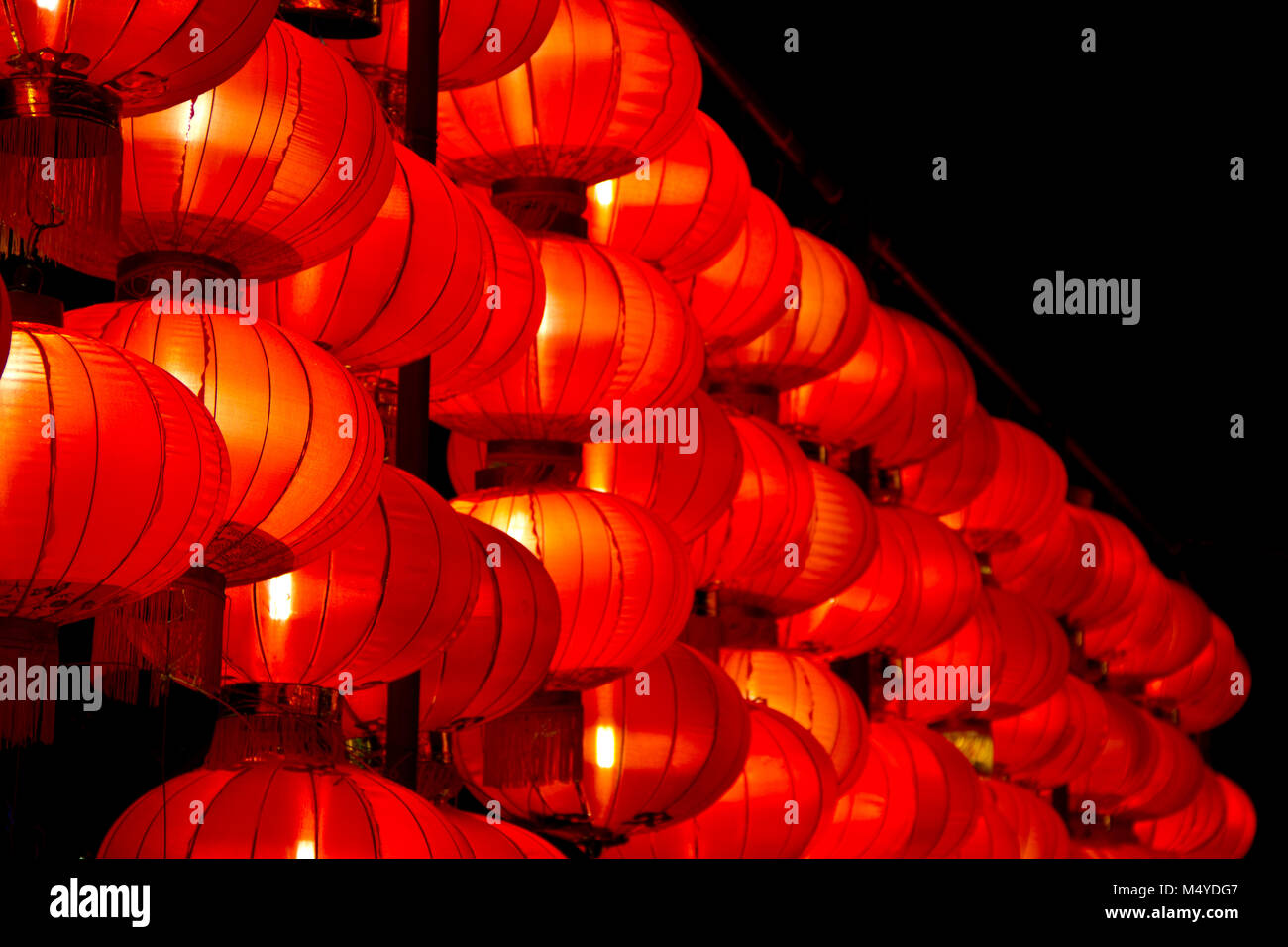 Eine Reihe von roten Lampions leuchten hell in der Nacht, selektiven Fokus. Stockfoto