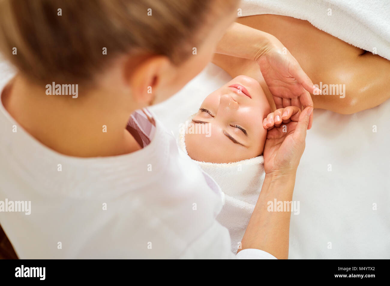 Schöne Frau an eine Gesichtsmassage in einem Spa Salon Stockfoto