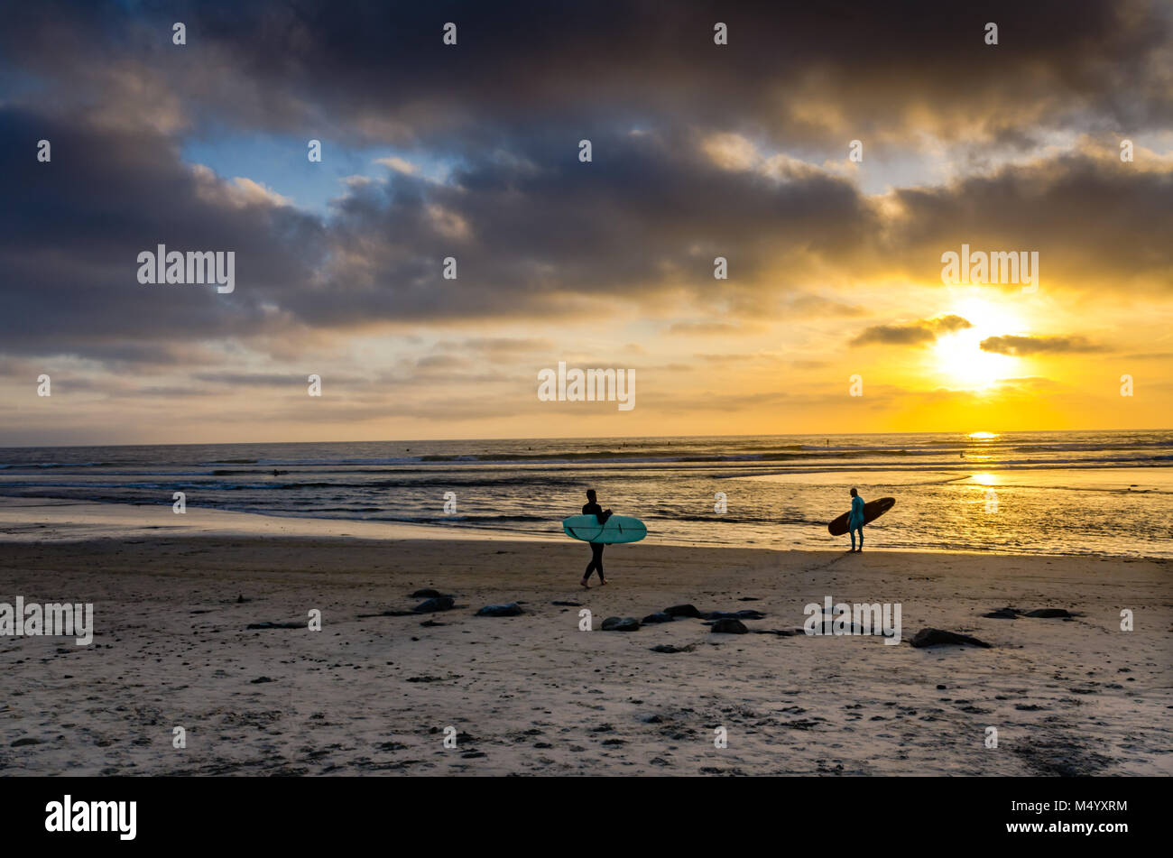 Zwei Surfer in den Ozean bei Sonnenuntergang in Cardiff State Beach in der Nähe von San Diego, Kalifornien. Stockfoto