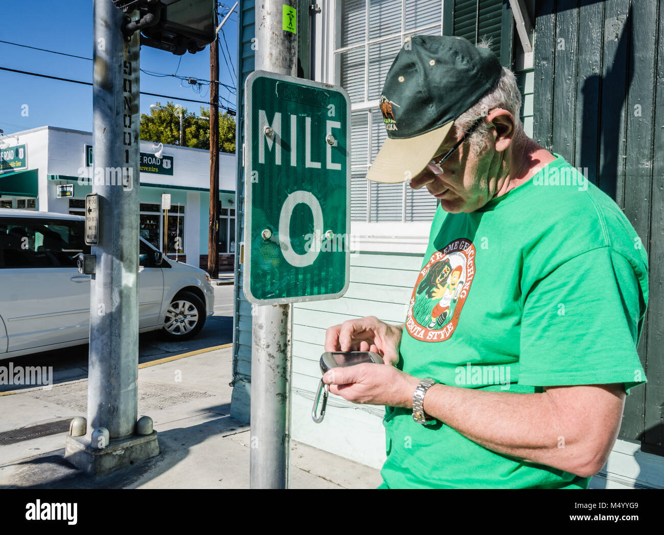 Geocacher prüft GPS am Anfang der US Route 1. US1 entlang der Ostküste von Florida, beginnend in Key West mit 2.369 Meilen (3,81 Stockfoto
