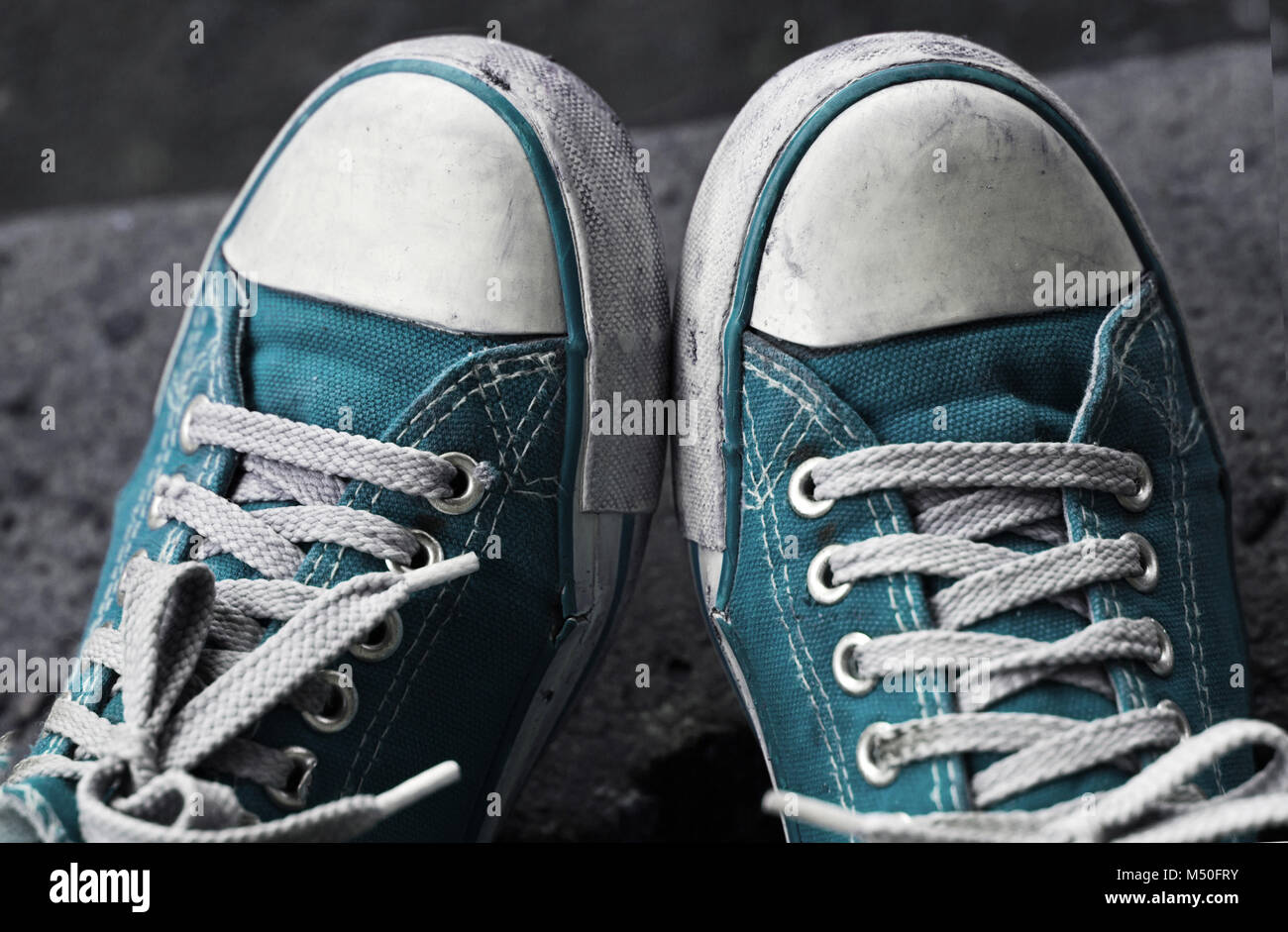 Füße in schmutzigen blauen Turnschuhe und Jeans im Freien. Der erste Schritt. Stockfoto