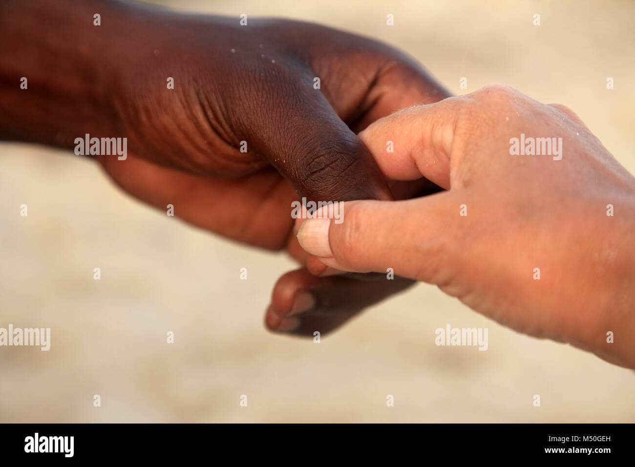 Hände von einer weißen Frau und einem afrikanischen Mann Stockfoto