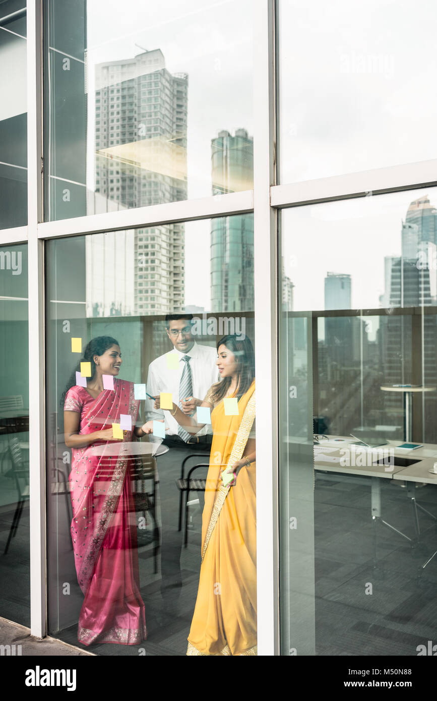 Indische Mitarbeiter haften Erinnerungen auf Glas Wand im Büro Stockfoto