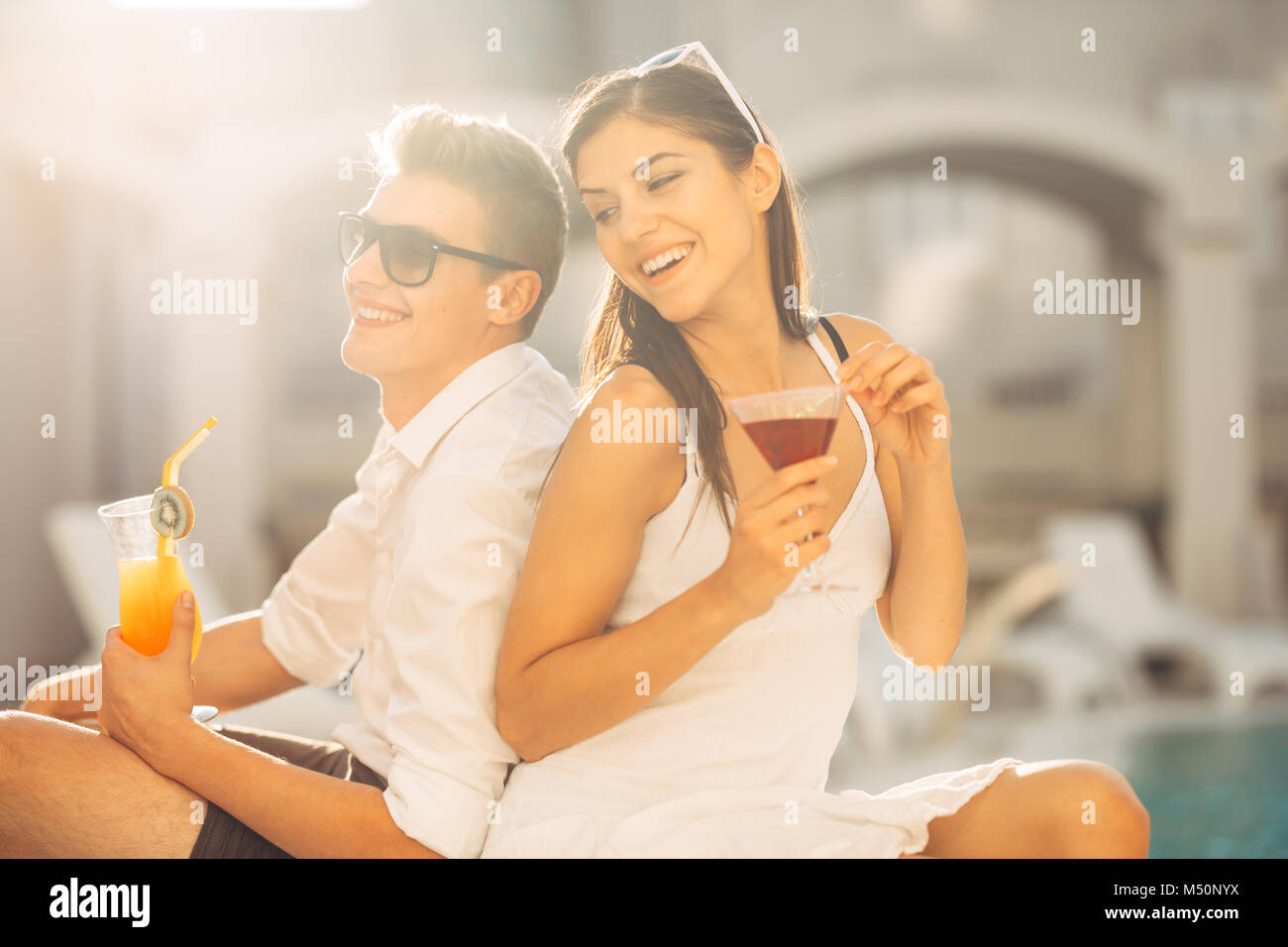 Zwei attraktive Leute Cocktails vom Pool im Sommer Vacation Resort. Pool Lounge Bar Party. Paar auf exotische Reisen Urlaub genießen Refre Stockfoto