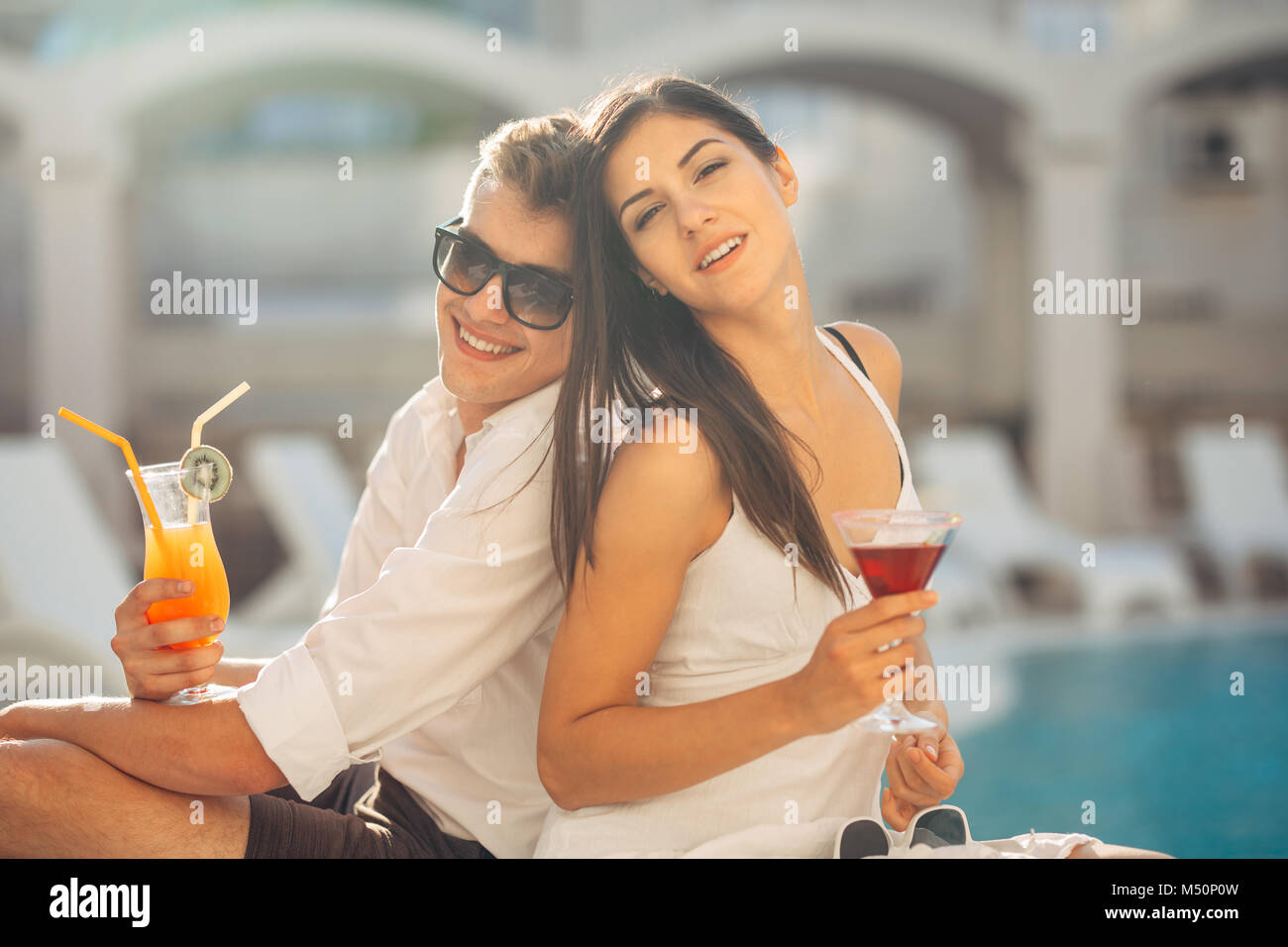 Zwei attraktive Leute Cocktails vom Pool im Sommer Vacation Resort. Pool Lounge Bar Party. Paar auf exotische Reisen Urlaub genießen Refre Stockfoto