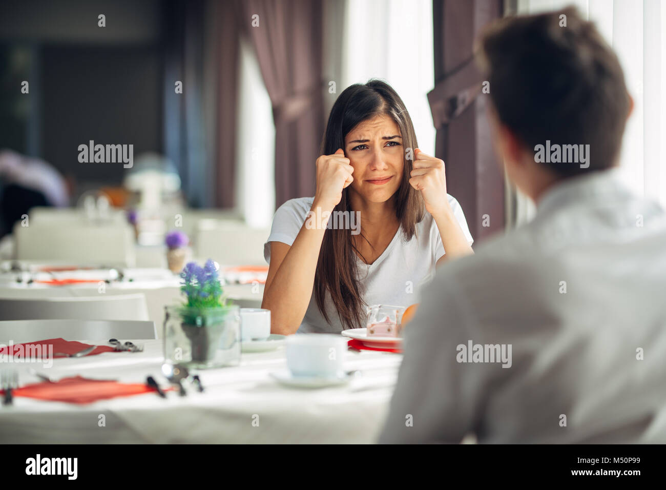 Verzweifelt weinende Frau kämpfen und streiten. Anhörung schlechte Nachrichten, negative Ereignis Reaktion. Emotionale Gesicht, enttäuschte Person. Probleme im Leben, Beziehung Stockfoto