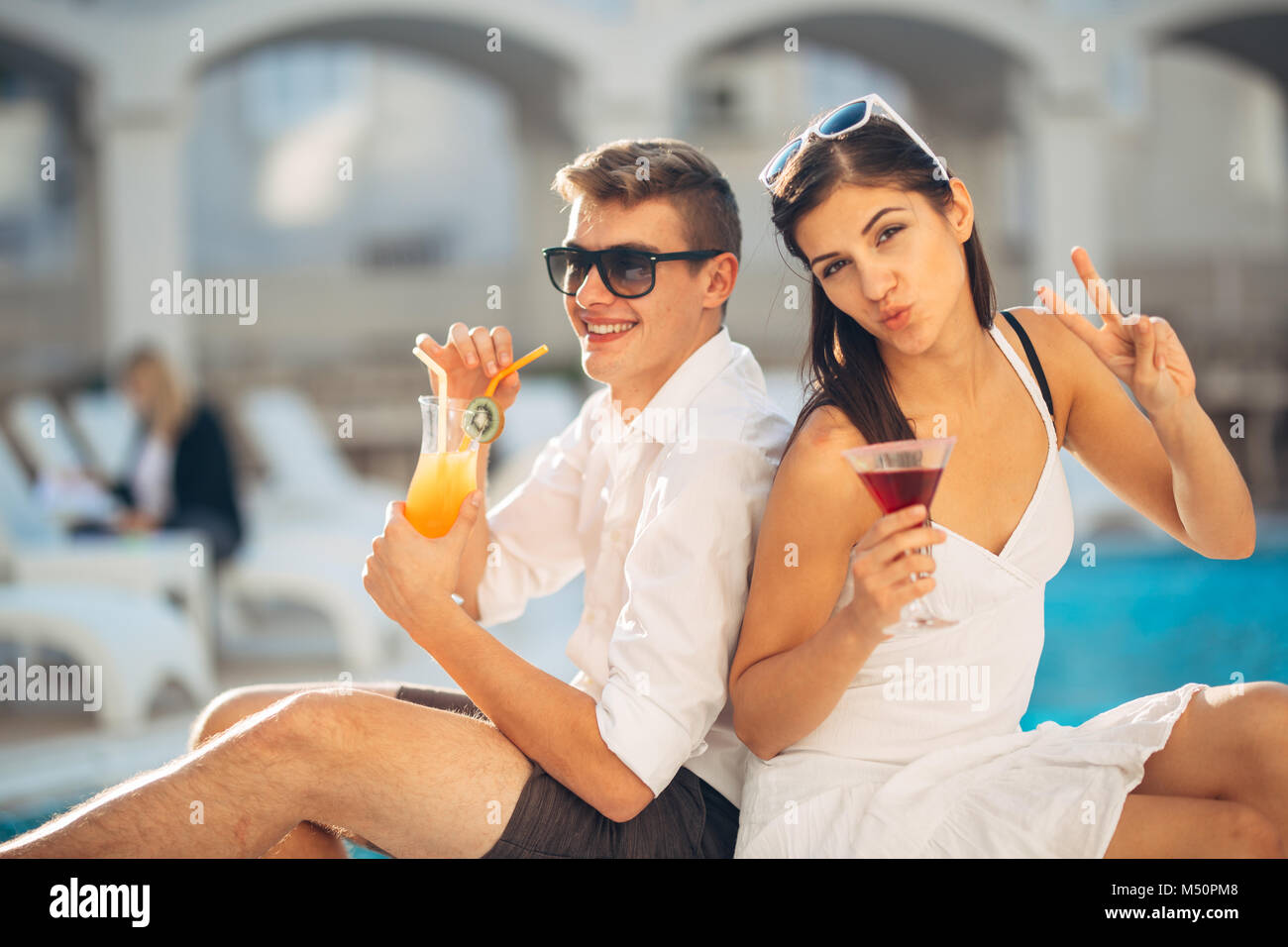 Zwei attraktive Leute Cocktails vom Pool im Sommer Vacation Resort. Pool Lounge Bar Party. Paar auf exotische Reisen Urlaub genießen Refre Stockfoto