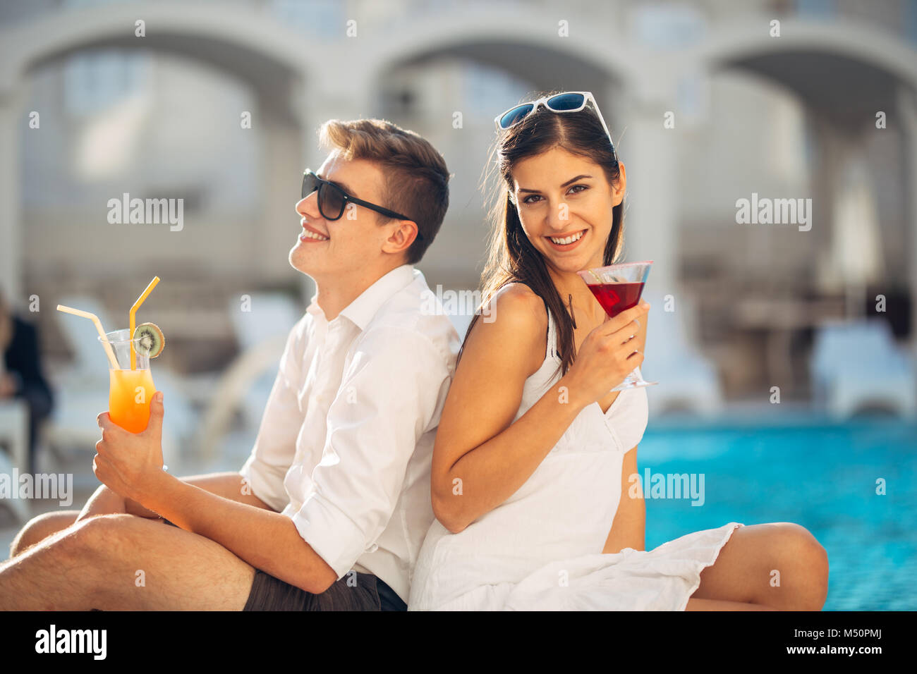 Zwei attraktive Leute Cocktails vom Pool im Sommer Vacation Resort. Pool Lounge Bar Party. Paar auf exotische Reisen Urlaub genießen Refre Stockfoto