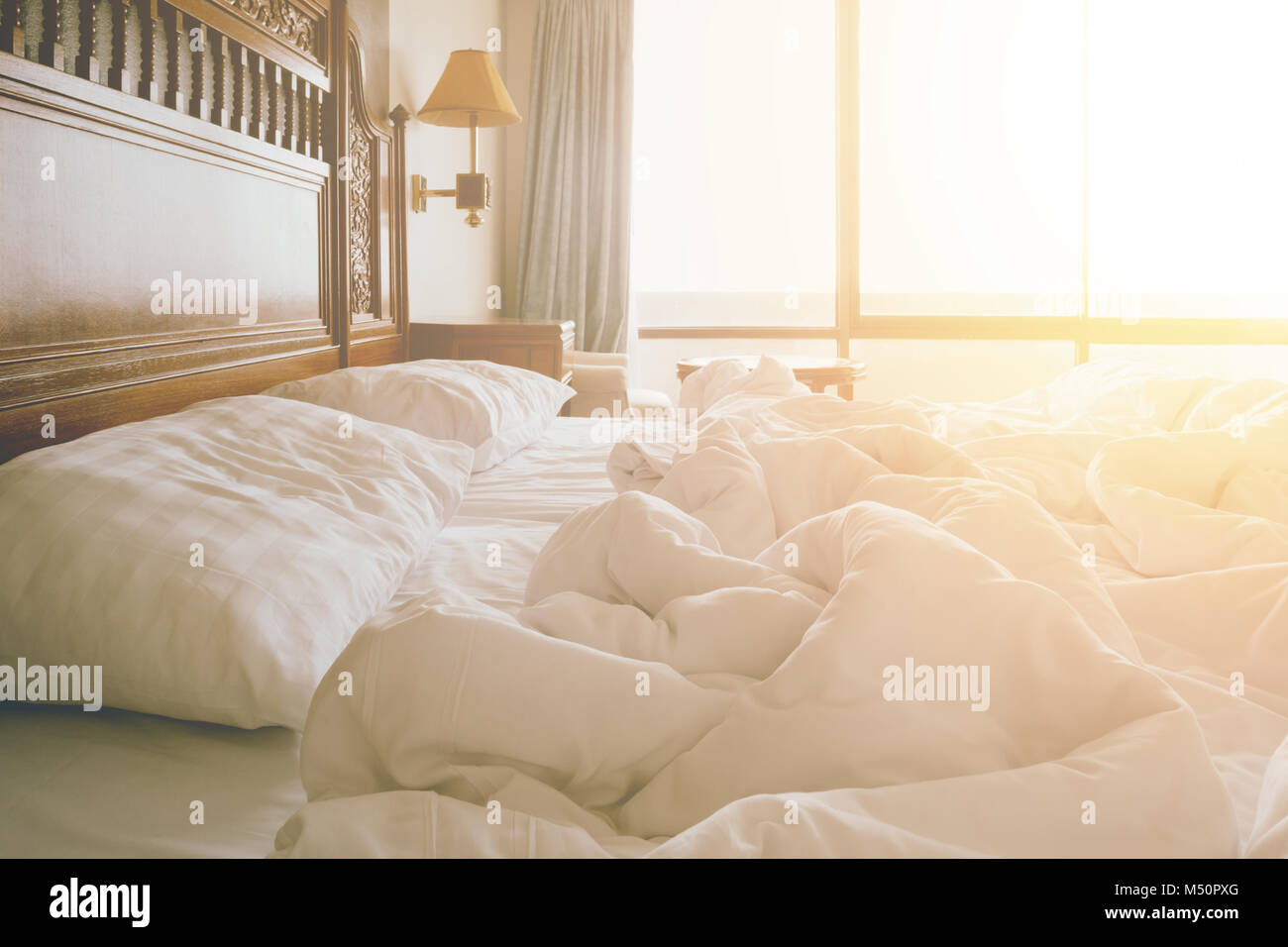 Ungemachten Bett mit zerknitterten Bettlaken und Kissen nach Komfort Bettdecke schlafen, Aufwachen am Morgen Stockfoto